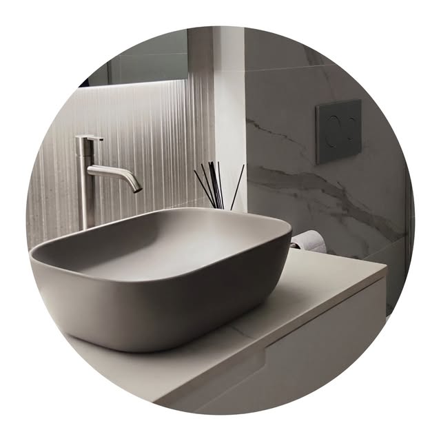 Baño con lavabo sobre encimera gris mate